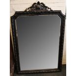 A French bevel edge mirror, decorative crest over