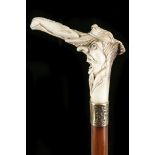 A FOLK ART CANE. With the carved antler portrait h