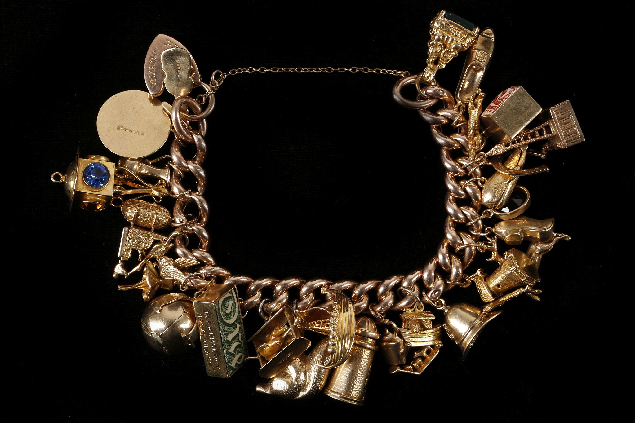 A 9ct rose gold, 29 piece charm bracelet with all