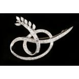 An Art Deco white gold and diamond set ribbon scro