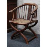 A colonial horseshoe chair, hardwood curve with 'walnut' arms, solid splat with strap-work