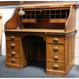 A 1930's roll top tambour desk, oak, pigeon holes and drawers, set over 6 drawers (2 faux) with
