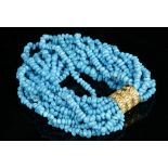 A multi-strand bracelet of turquoise beads, having 18 carat yellow gold clasp.