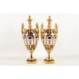 A pair of Royal Crown Derby, bone china twin handled urns, in Imari palette, pattern no. 1128,