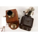 An early wall mounted telephone with wooden board and box and brass mounted speaker and