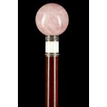 AN ELEGANT ROSE QUARTZ, ENAMEL AND HARDWOOD WALKING CANE. The spherical knop is on a silver and