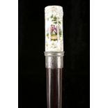 A PORCELAIN MOUNTED CANE. Circa 1900. The cylindrical knop painted with a scene depicting a courting