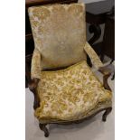 A 19t century French walnut Regence armchair, with carved decoration and yellow upholstery on