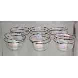 An early Art Deco Bohemian set of 12 iridescent glass bowls, black painted rim of Wiener