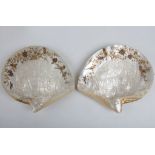 A pair of Chinese carved mother of pearl shells incised with landscape scenes, with further raised