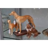 A collection of three figures of dogs, including two figures of greyhounds, one mounted on a