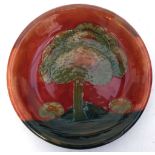 A William Moorcroft bowl in 'Eventide' pattern, decorated with stylised trees on a deep red sky, Wu'