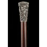 AN INTERESTING WALKING CANE. With a chased white metal 'Milord' knop, the crown decorated with