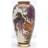 An early 20th century, Japanese earthenware baluster shaped vase, painted with flora and fauna