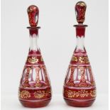 A pair of early 20th century Bohemian gilt and ruby flashed glass decanters, with panel, printle and