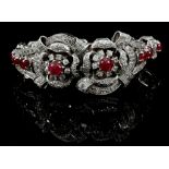A 14 carat white gold, diamond, and ruby bracelet, having ornately decorated clasp, set with