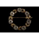 A yellow metal and diamond set wreath brooch, set seven round cut diamonds of approx. 2.10 carats