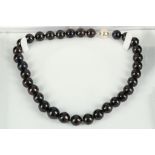 A necklace of cultured pearls having black South Sea style finish, and white metal magnetic clasp.