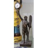 Novelty clock; a bronzed figure of an airman holding a propeller in one hand and supporting a