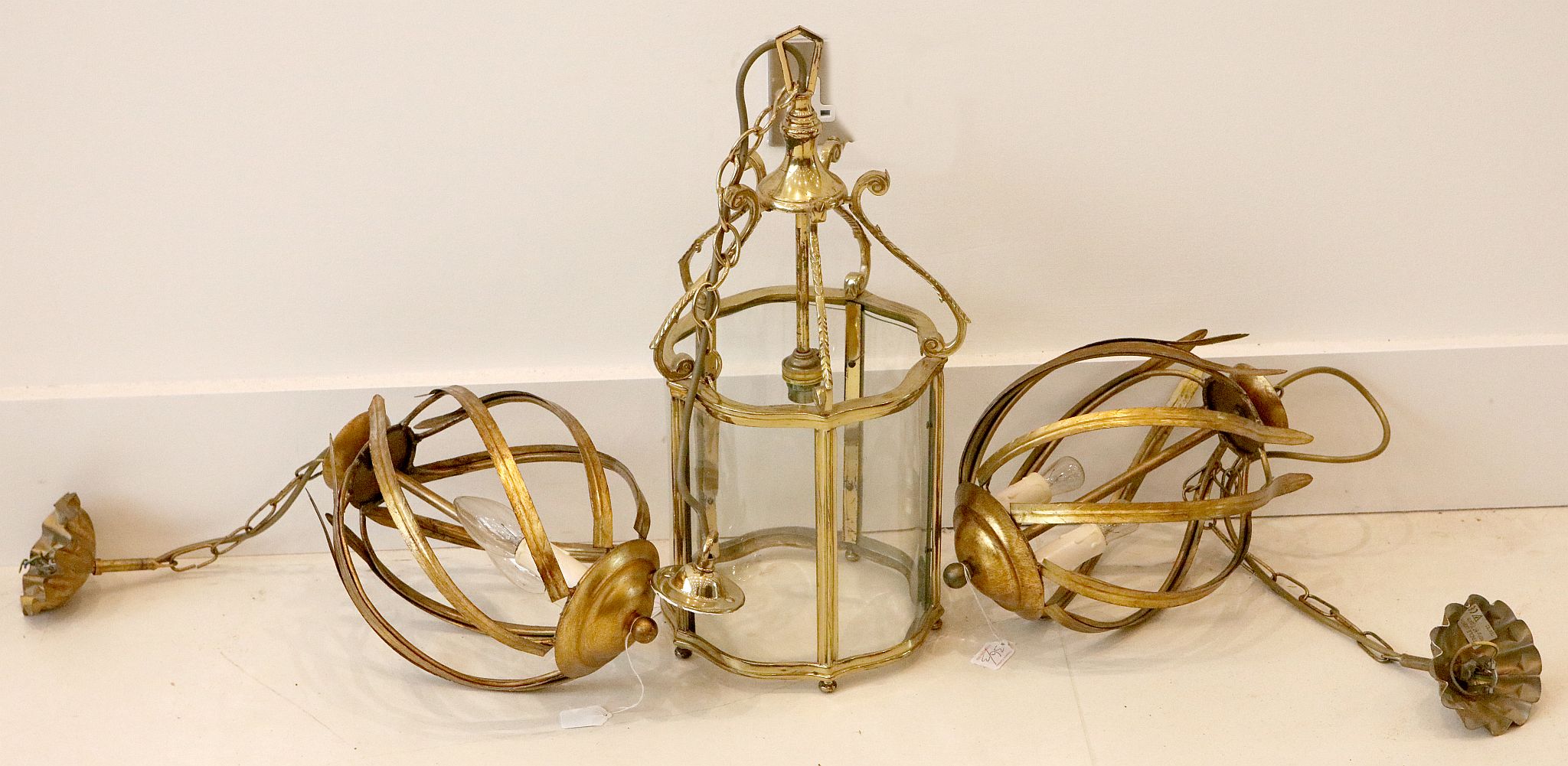 A brass hall lantern, having 6 shaped glass panes, scroll supported, 48cm high, with a pair of