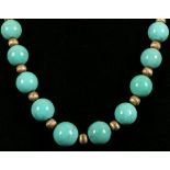 A graduated turquoise and yellow metal bead necklace, having rounded natural turquoise beads,