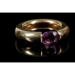 An unusual yellow metal and pink sapphire ring, having suspension set cushion cut sapphire of