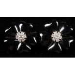 A pair of 18 carat white gold, diamond, and black onyx flower earrings, set seven round cut