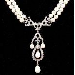 A double strand pearl necklace, having white metal and diamond set drop pendant (tests as gold),