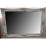 A large modern mirror, with ornate white painted carved wooden frame, 215 x 103cm.