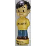 Sony - a shop display of a young boy in yellow T-shirt with the word 'Sony', supported on a circular