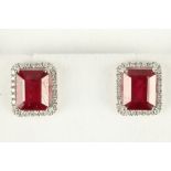 A pair of 18 carat white gold, diamond, and ruby ear studs, each set emerald cut ruby of approx. 5.0