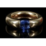 A yellow metal and blue sapphire ring, the suspension set stone of approx. 0.50 carats, having