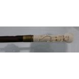 A modern marine ivory cane, the grip carved with a skeleton and the mahogany shaft terminating at