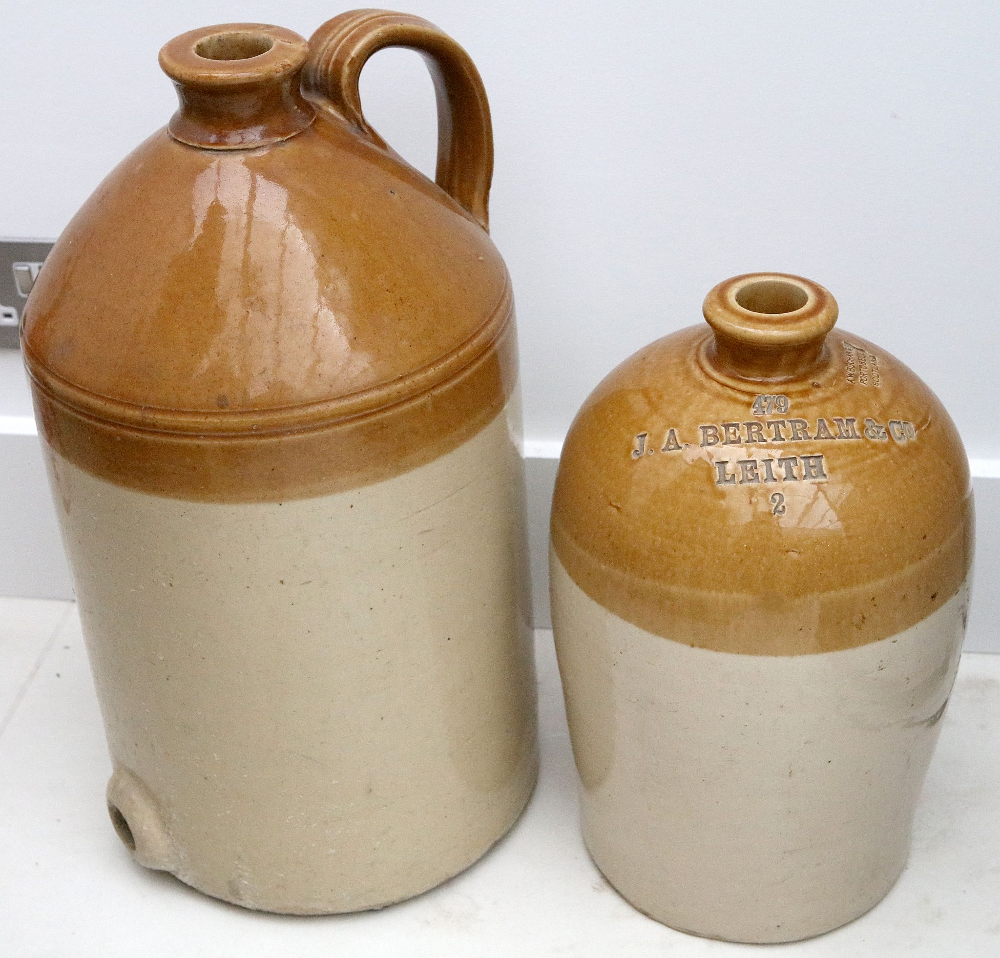 A two colour stoneware jar with incised name J.A. Bertram & Co - Leith, 39cm high, with a larger