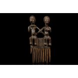 A LUBA COMB, DEMOCRATIC REPUBLIC OF CONGO With eleven teeth, the handle decorated with a seated
