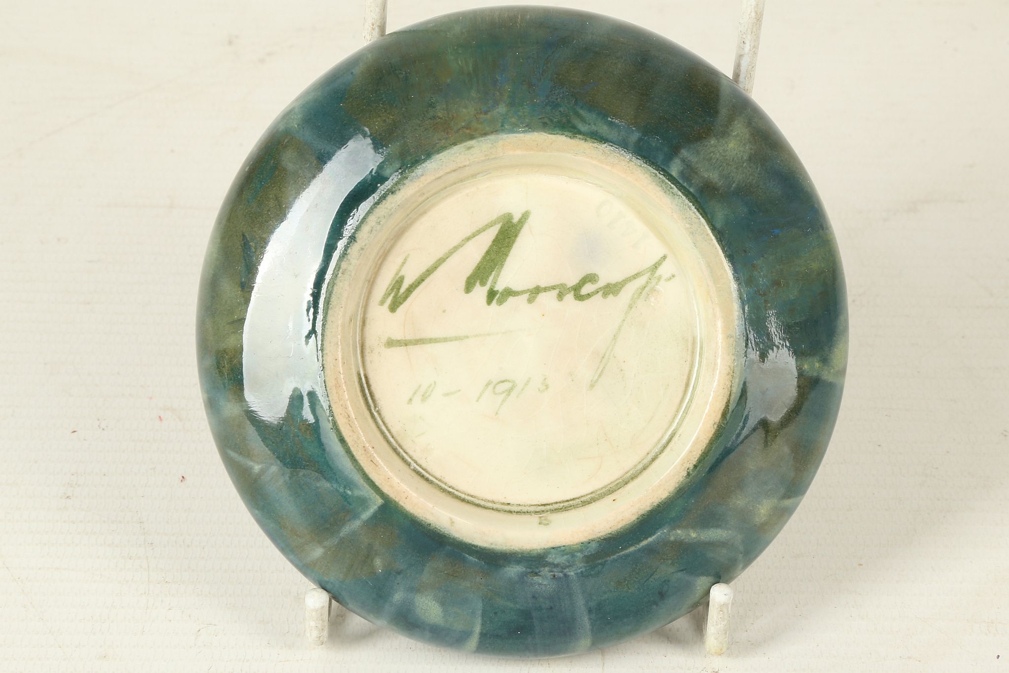 AN EARLY 20TH CENTURY WILLIAM MOORCROFT POTTERY INVERTED RIM CIRCULAR DISH, dated Oct. 1913, green - Image 2 of 2