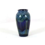 A WILLIAM MOORCROFT BALUSTER SHAPE VASE, CIRCA 1925, in 'Moonlit Blue' pattern, painted green