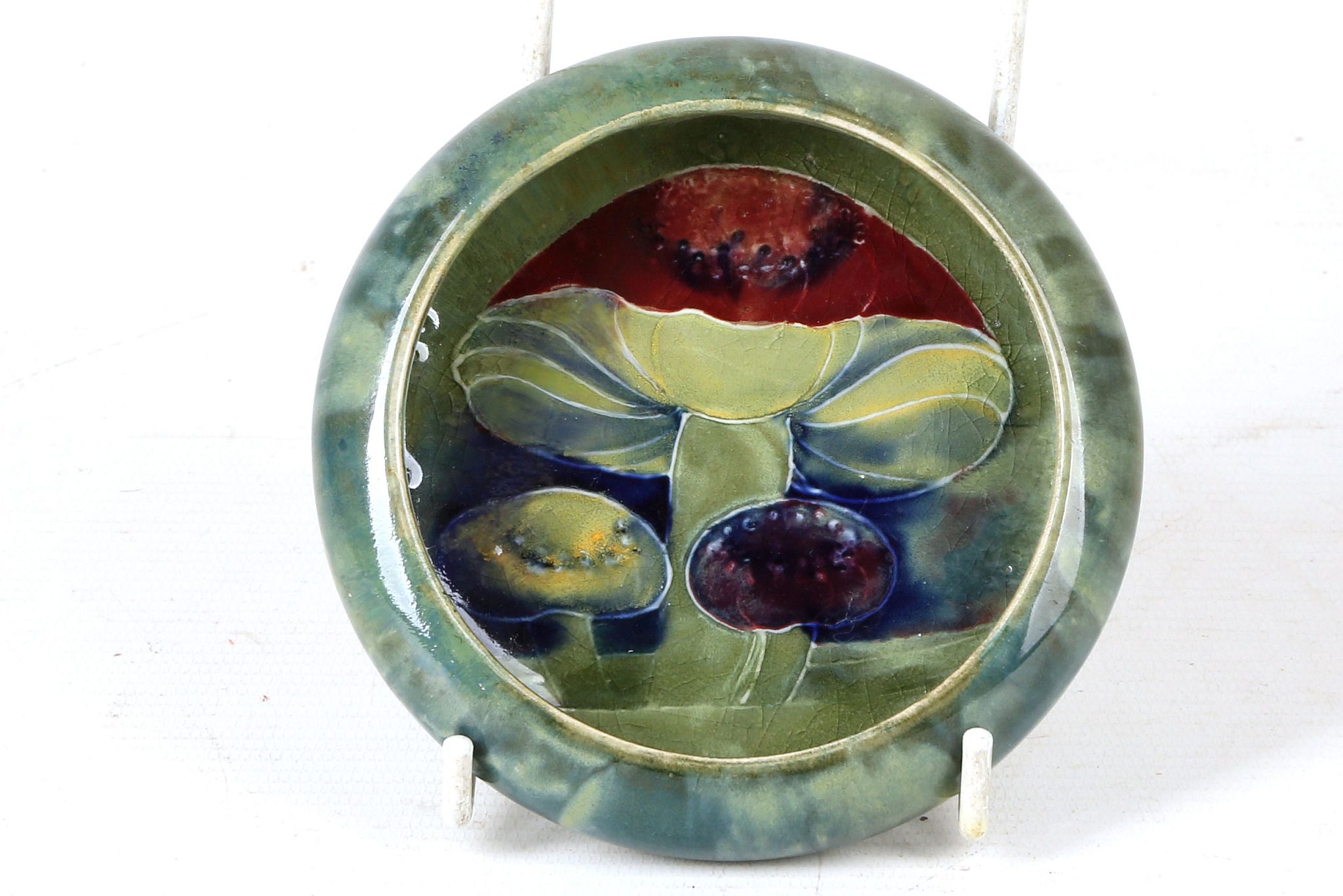 AN EARLY 20TH CENTURY WILLIAM MOORCROFT POTTERY INVERTED RIM CIRCULAR DISH, dated Oct. 1913, green