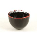 A LATE 20TH CENTURY BLACK STUDIO GLASS BOWL, with interspersed red glass rim, indistinctly signed