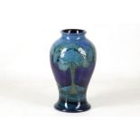 A WILLIAM MOORCROFT POTTERY BALUSTER SHAPED VASE, in 'Moonlit Blue', c.1925, green signature, 16.5cm