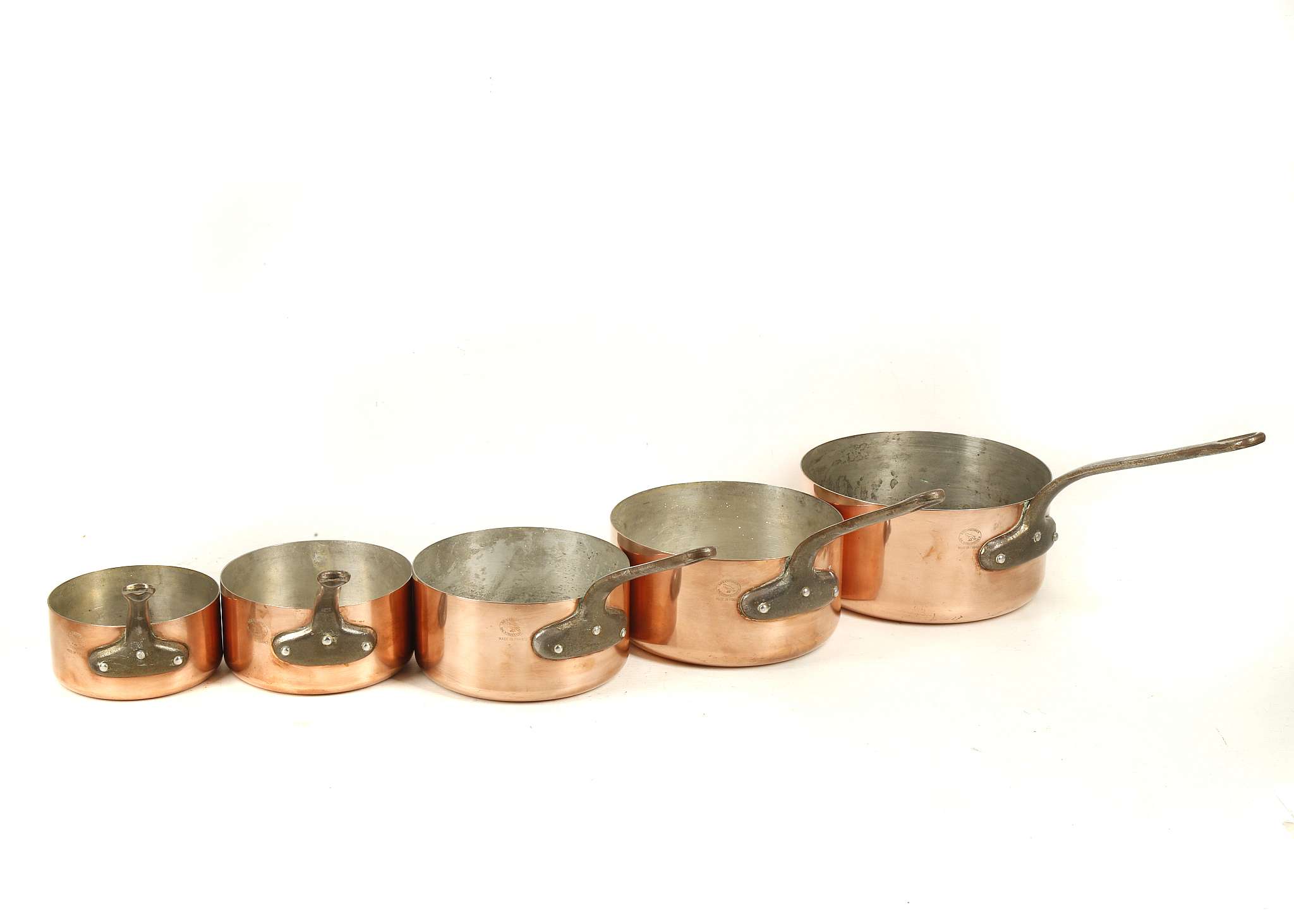 A graduated set of 5 copper saucepans, 'Les Cuivres de Faucogney' stamp, iron handles, largest