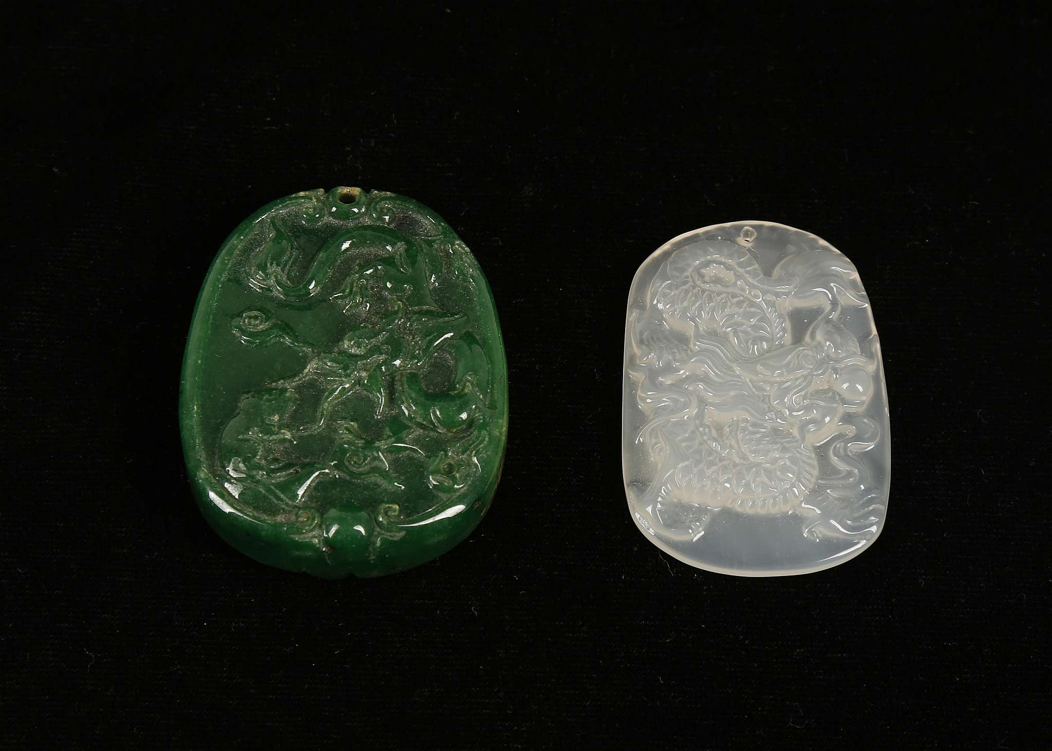 Two Chinese jade pendants; white with dragon, 5cm long, and spinach green with mouse and plants,