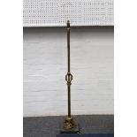 A mid 20th Century brass standard lamp base, supported to the base with a group of cherubs, raised