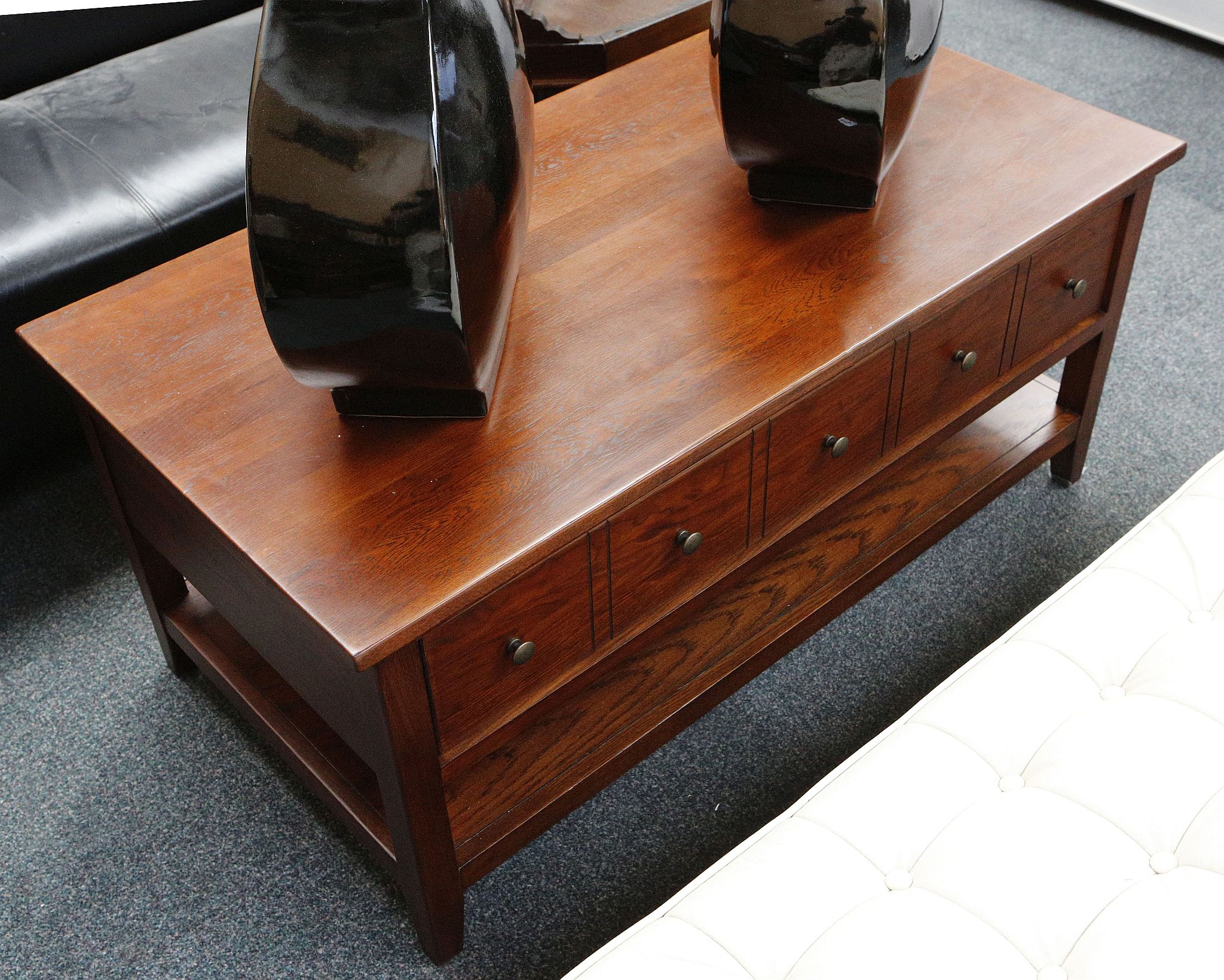 A pair of mahogany lounge stands, open tier with shaped apron over single drawer set on block