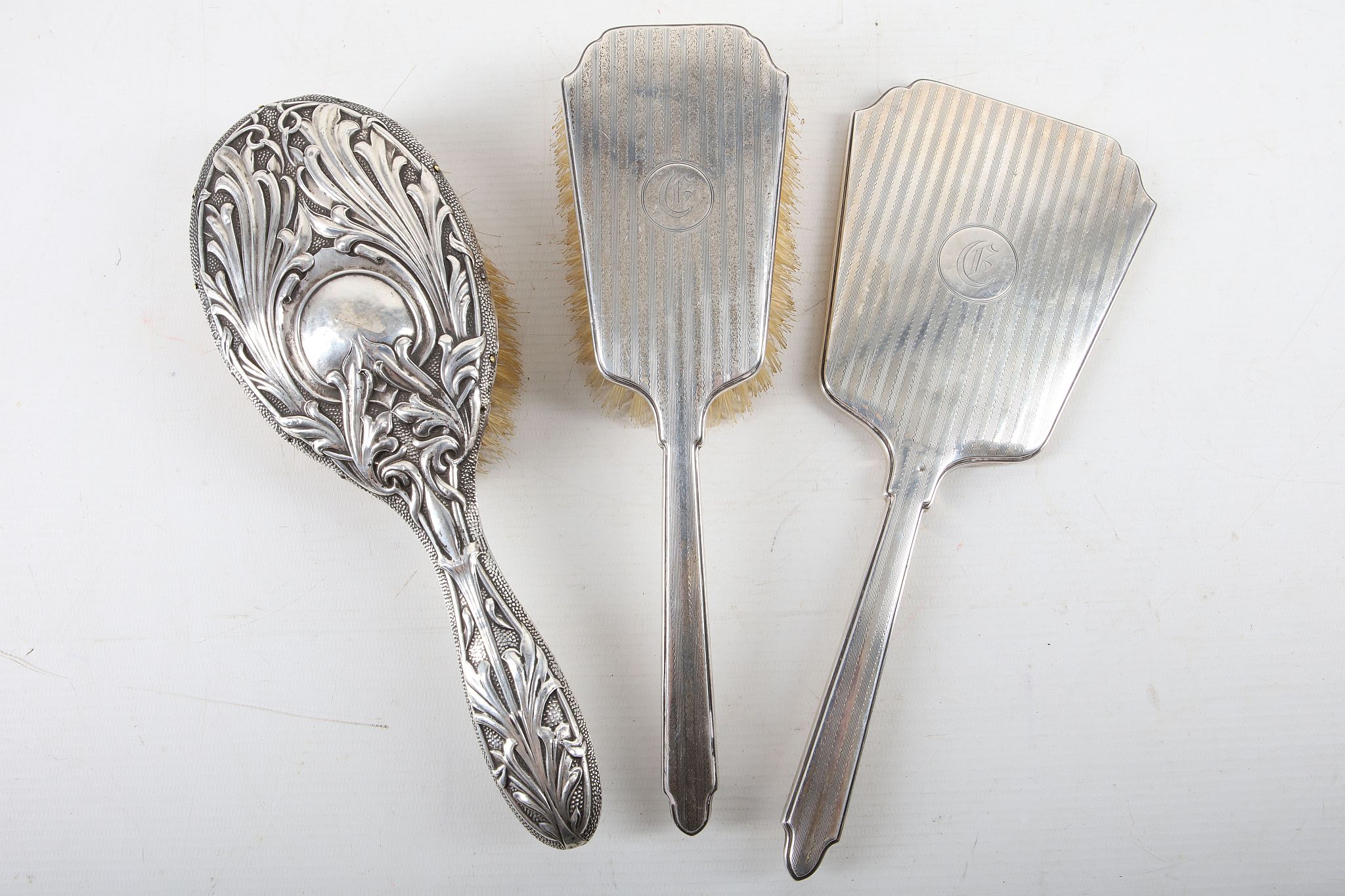 Two Silver backed dressing table hair brushes and a hand mirror. (3)