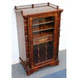 A Victorian music cabinet in marquetry inlaid burr walnut, having a gilt gallery to top, turned