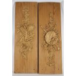 A pair of Edwardian wood panels, each with decoratively carved musical items and swags, 91 x 29cm (