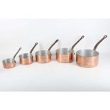 Five graduated copper saucepans with iron handles (5).