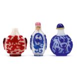 THREE CHINESE OVERLAY GLASS SNUFF BOTTLES. Qing Dynasty. Comprising a red overlay snowflake snuff