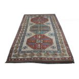 A Turkish Kars carpet, ivory ground with blue and rose medallions, 2.50m x 1.66m.